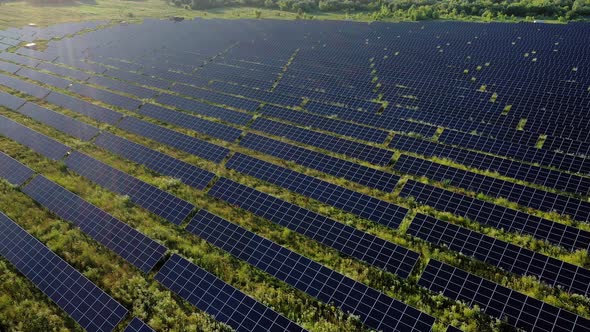 Top view of a massive photovoltaic power station located in a field at sunse alt