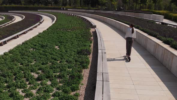 Drone Follows Businesswoman Riding Electric Kick Scooter. alt
