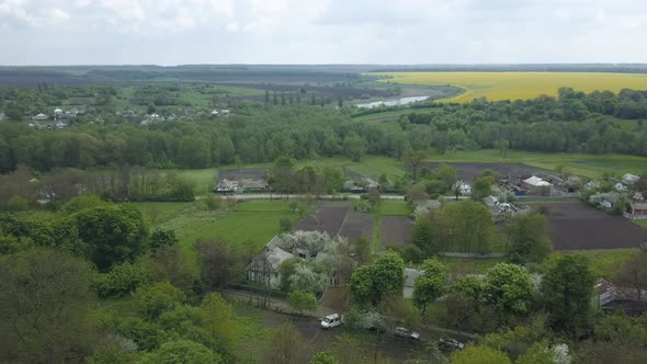 Picturesque top view of countryside village with green forest, houses, fields, meadows
