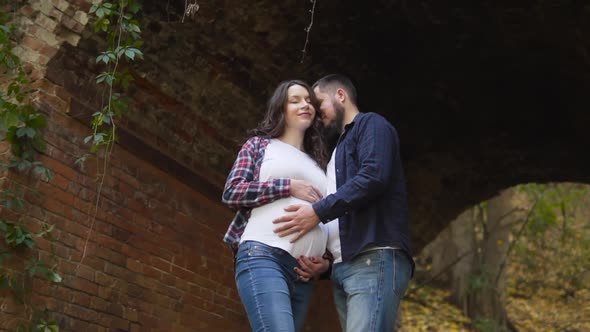 A Happy Married Couple Waiting for a Child Hugs on the Ruins of an Ancient Castle