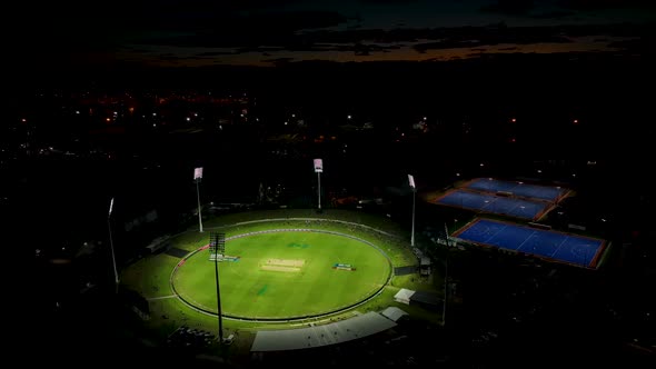Aerial pan of sports grounds with games being played under lights. Tauranga New Zealand. alt
