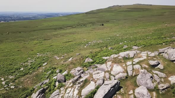 Aerial flyover of granite rocks in Dartmoor, England alt