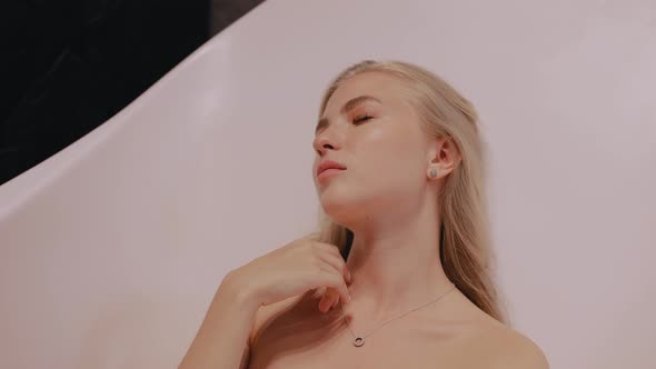 Young Blonde Takes a Bath in the Morning Relaxes Before a Difficult Day alt