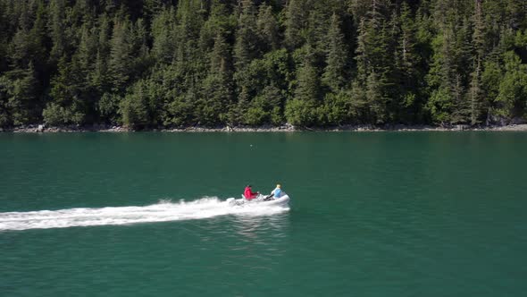 People In Speedboat Sailing On Turquoise Blue Lake In Alaska On A Sunny Day - tracking shot alt