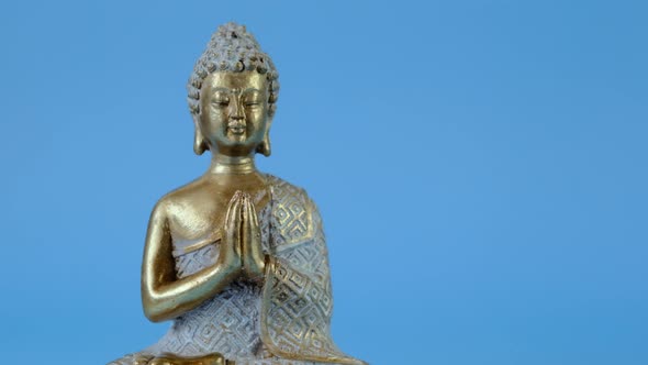 Buddha statue on a blue background.Meditation and relaxation symbol.Buddhism religion background. alt