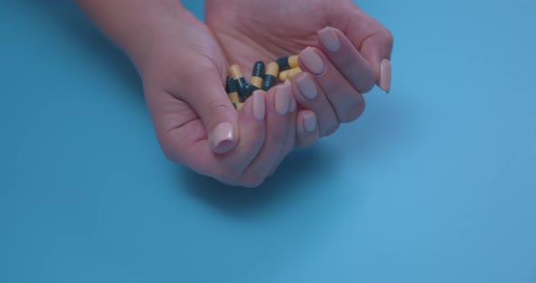 Closeup of a Woman's Hands with a Handful of Pills