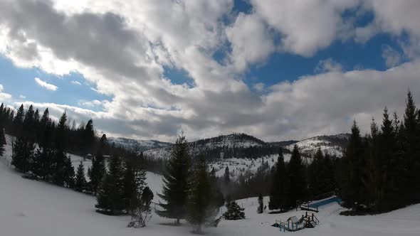 Timelapse clouds floating the sky. Snowed hills and mountains. Winter time.