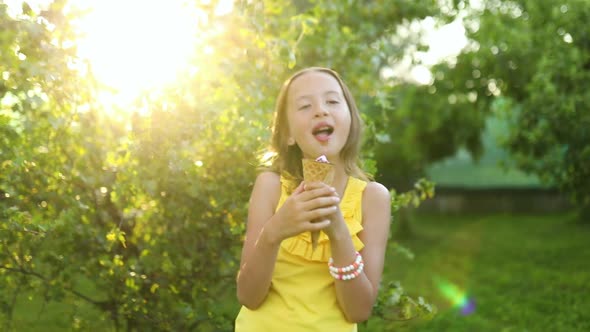 Happy girl eating italian ice cream cone smiling while resting in park on summer day