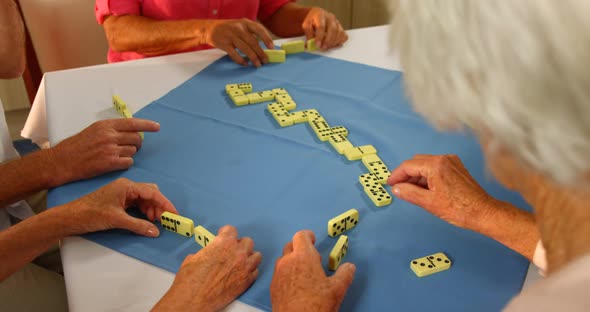 Senior friends playing dominos alt