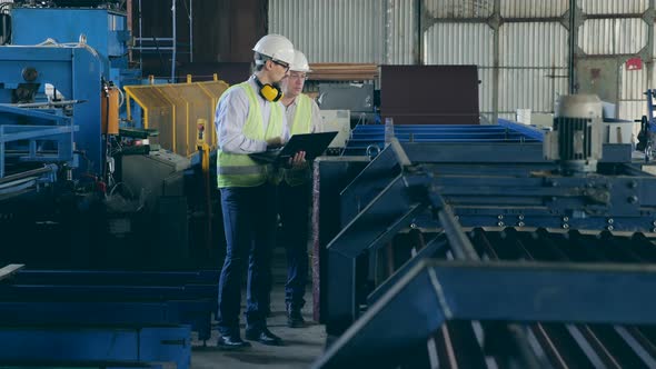 Factory Experts Are Walking Along the Metal-processing Conveyor alt