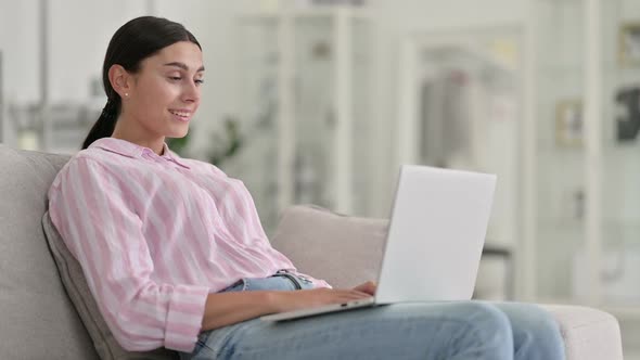 Professional Young Latin Woman Doing Video Call on Laptop at Home alt