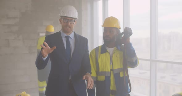 Businessman and Foreman in Hardhat Discussing Renovation Plan at Construction Site alt