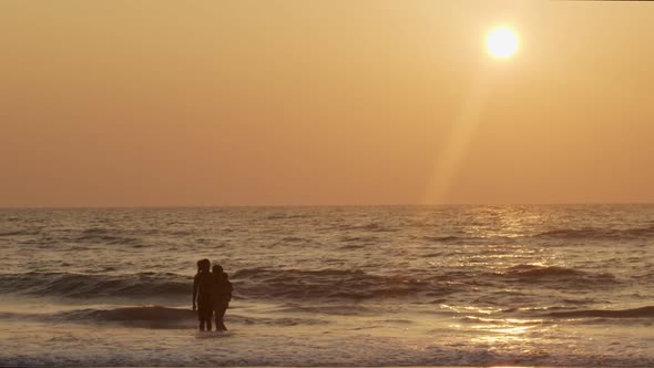 Happy Family Swimming in Ocean Water Backlit By Golden Sunset Light Copy Text Space. Man Woman Kid