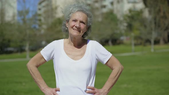 Smiling Senior Woman Posing on Green Meadow alt