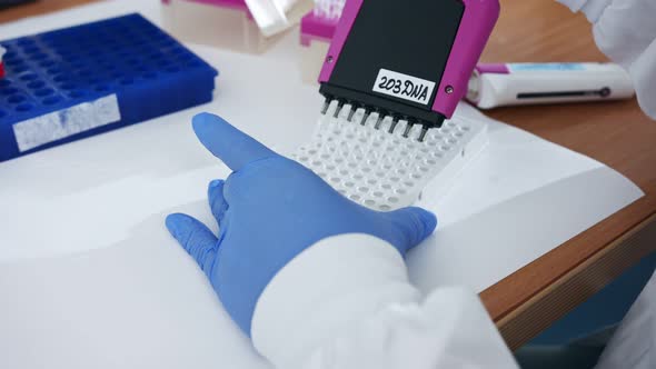 Scientist using a multichannel Pipette to collect samples in a chemistry lab alt