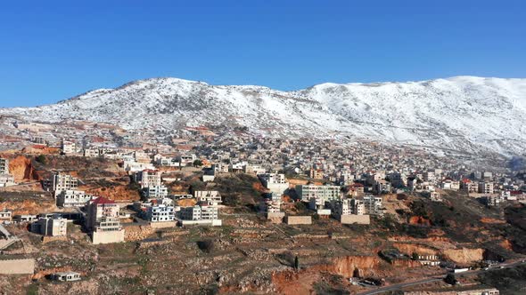 Hermon mountain ridge covered with snow during 2022 winter, with the town houses of Majd al Shams. alt