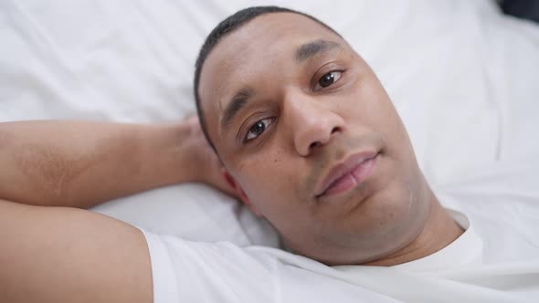Closeup Face of Young Relaxed African American Man with Brown Eyes Looking at Camera Smiling alt
