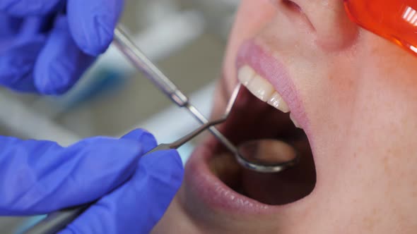 Dentist Treating Teeth to Woman Patient in Clinic alt