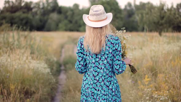 Girl With Wildflower On Wildflower Field.Woman Walking On Meadow.Woman With Bouquet In Meadow Flower alt