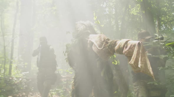 Marine Corps Detachment in Combat Gear Moving Forward in Fog of Forest alt
