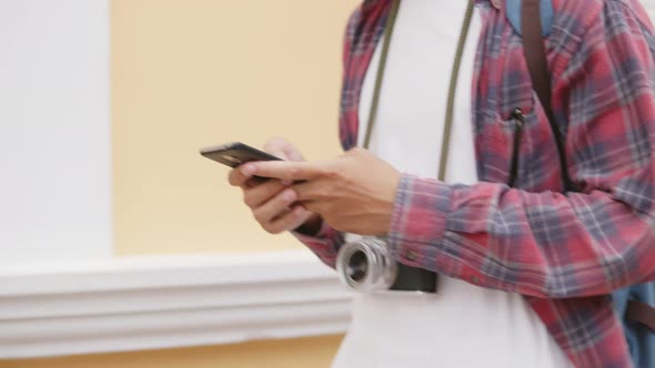 Tourists are Asian man using smartphones checking social media while walking on the street.