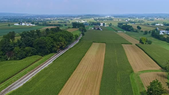 Aerial Lowing View of Fertile Corn Fields With a Rail Road Track Running Thru alt