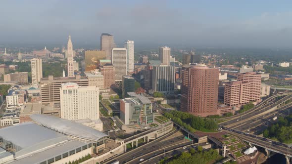 Aerial of busy street and high-rise buildings along river coast Hartford alt