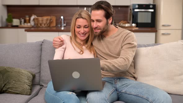 Overjoyed Couple in Love Spending Leisure Time Online with Laptop at Home