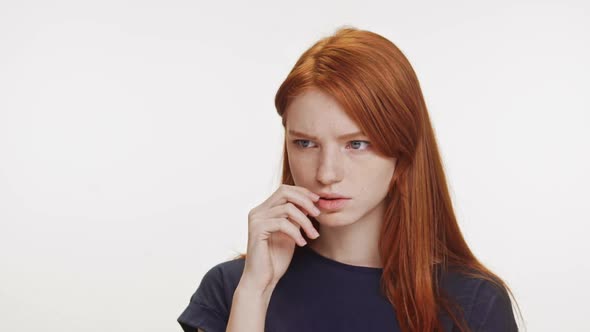 Thoughtful Redhaired Caucasian Teenage Girl Wearing Dark Blue Tshirt Trying to Remember Something on alt