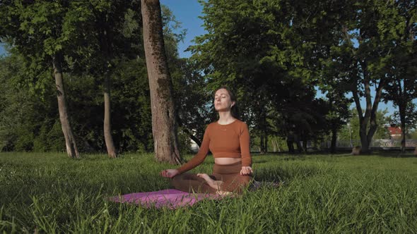 Woman doing yoga exercise in park outdoors
