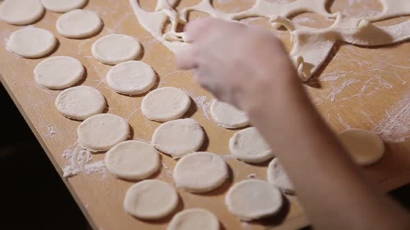 Woman molds dough at home. Roll out the dough with a rolling pin alt