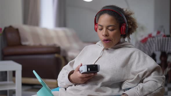 Middle Shot of Dissatisfied African American Woman Printing Remote Working with Label Maker Sitting alt