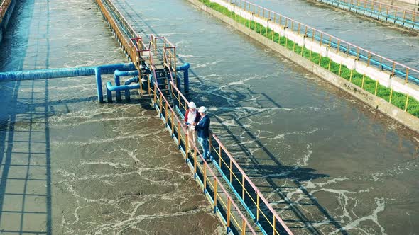 Wastewater Cleaning Site with Two Technicians Filmed From Above alt