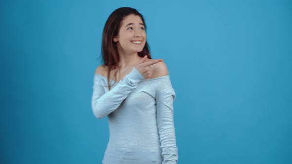 The Young Woman Points with Her Left and Right Finger Surprised By What is Displayed alt