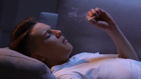 Depressed Teen Trying to Smoke Cigarette, Inhaling Smoke and Coughing, Problem alt