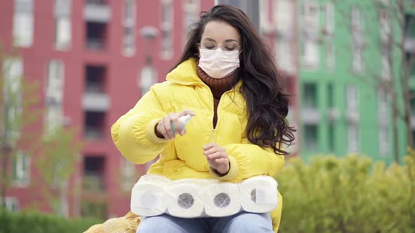 Woman sitting on the bench and using antiseptic spray