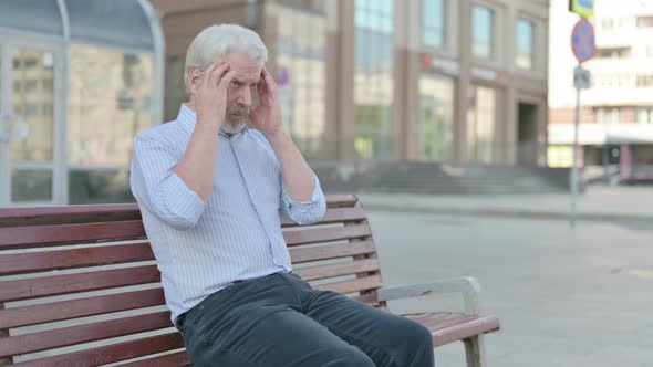 Old Man with Headache Sitting Outdoor on Bench alt