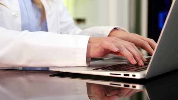 Optometrist using laptop in ophthalmology clinic alt