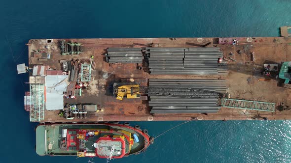 Aerial top down of cargo transportation by construction materials transported building pipes and met alt