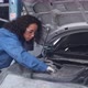 Young woman is mechanic repairing engine of car in the garage. - VideoHive Item for Sale