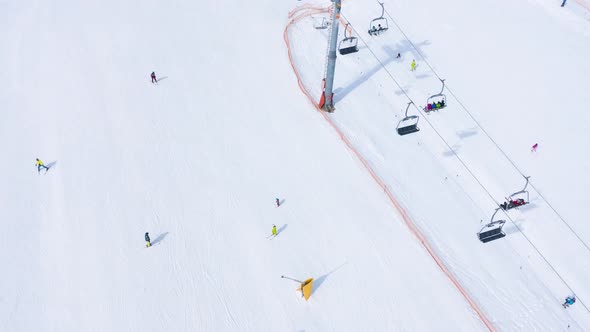 Aerial Hyperlapse of Ski Slope  Ski Lift Skiers and Snowboarders Going Down alt