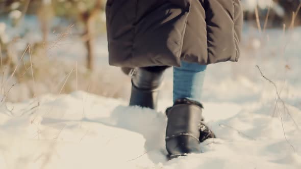 Legs Footprints In Winter Boots Walking On Snow. Female In Snowy Weather At Cold Temperature Walking alt