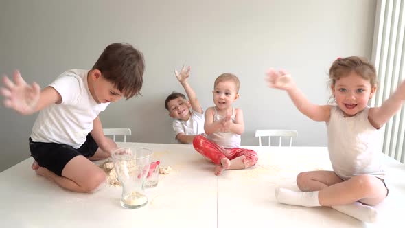Happy Family Having Fun with Flour While Cooking Cookies. Kids Helping Mother To Knead the Dough