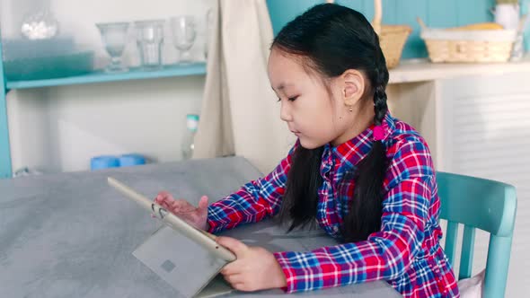 Little Asian Girl Using Digital Tablet at Home