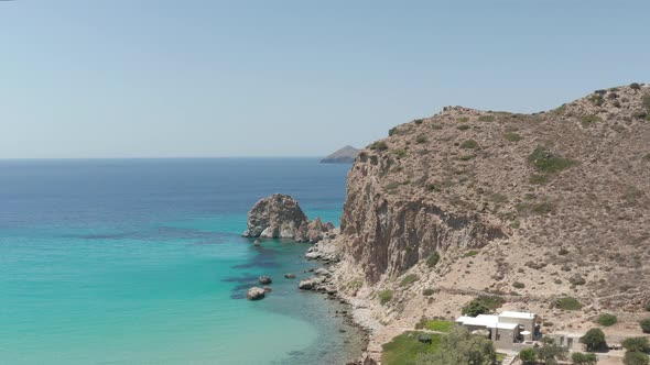 Slow Aerial Flight Over Turquoise Blue Ocean with Rocky Cliff Coast alt