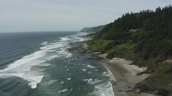 Slowly rising drone shot of rocky Oregon sea cliffs alt