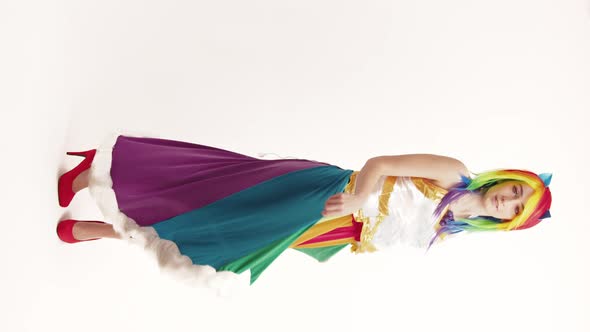 Vertical Colorfully Dressed Young Caucasian Woman in Her 20s Pinning Around and Goofing Around alt