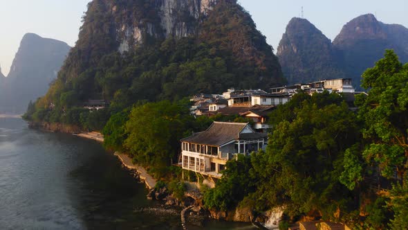 Waterfront buildings at the foot of karst mountain on the banks of Li river, Yangshuo, China alt