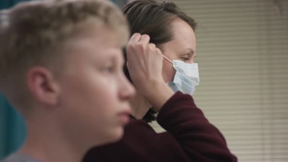 A Side View Slow Motion Portrait of a Teacher and Her Student Putting Medical Masks on Their Faces