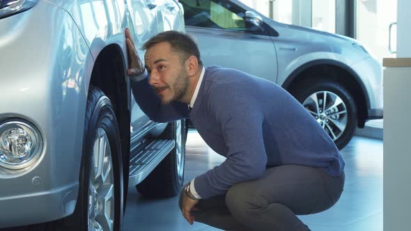 Attentive Man Examines in Great Detail the Car